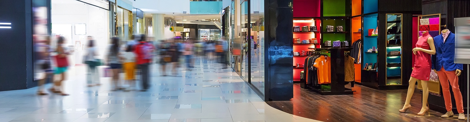 En färgsprakande bild på en klädaffär med öppen yta i ett välbesökt shoppingcenter 